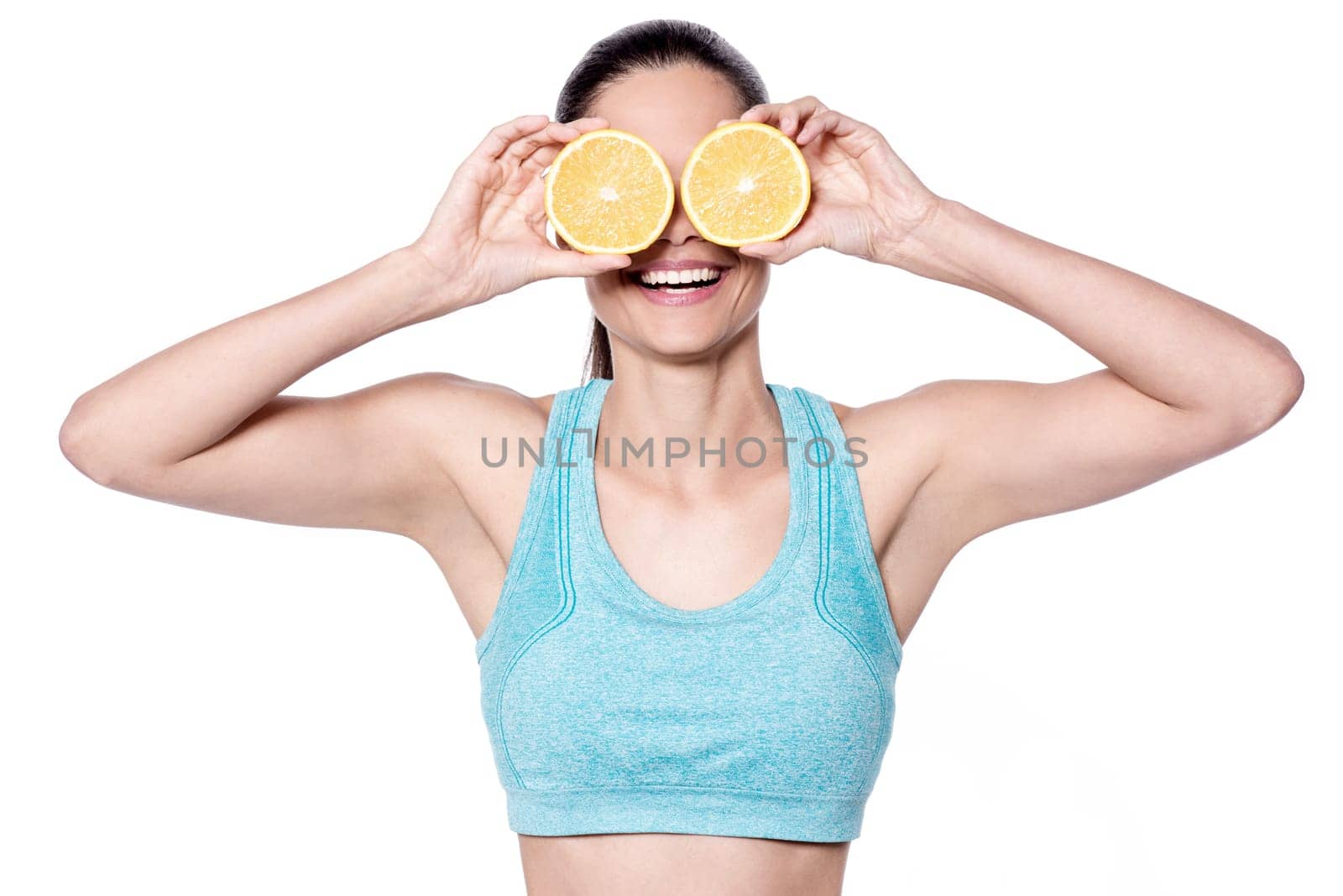 Fit young woman showing sliced orange