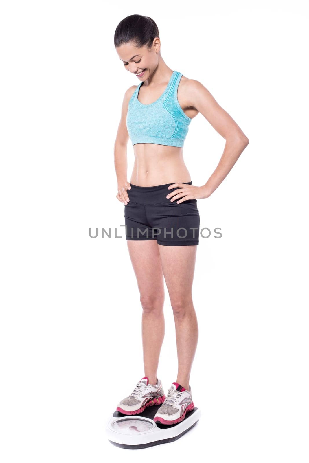 Young fit woman on weigh machine