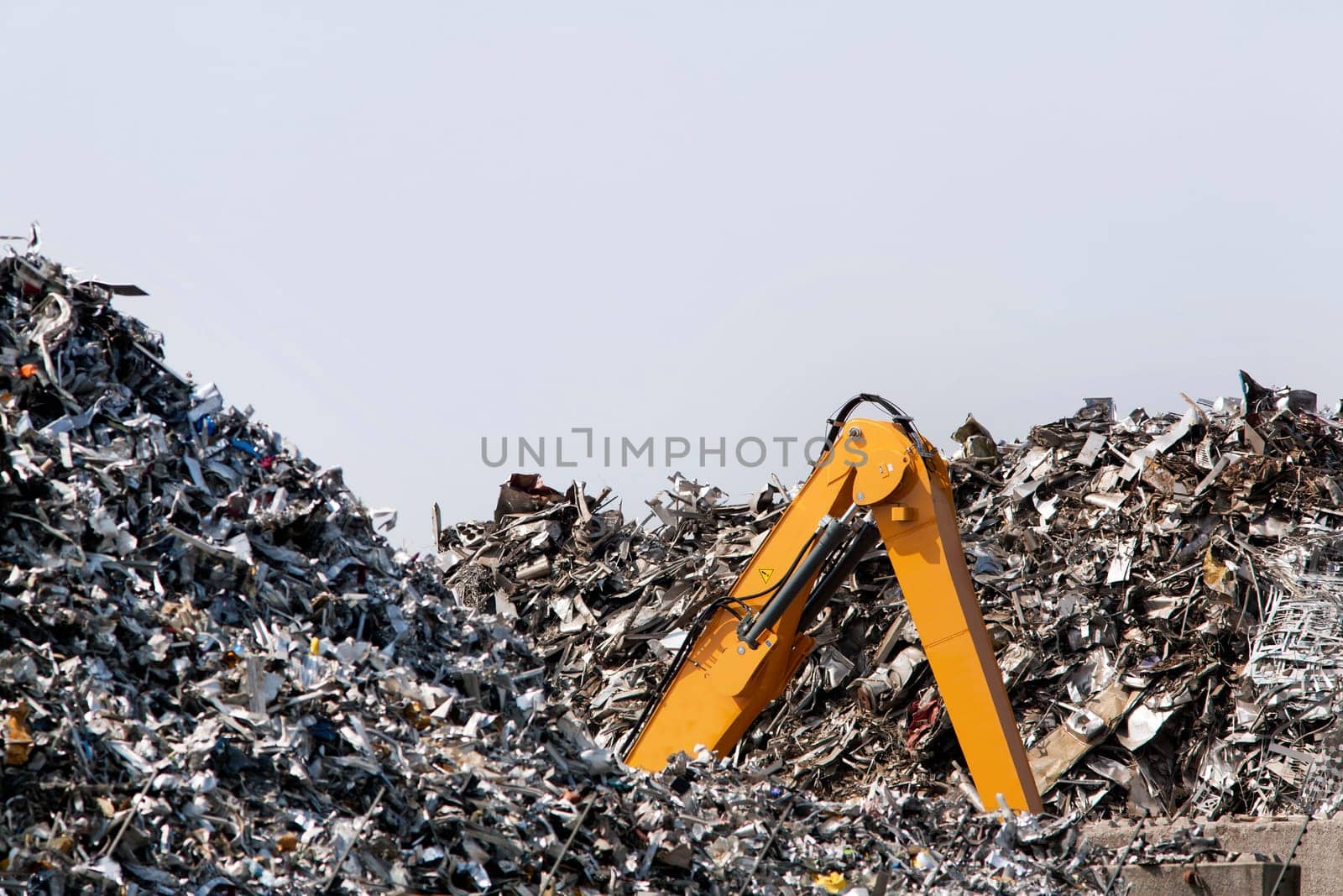 This brand new crawler excavator looks buried in the metal scrap