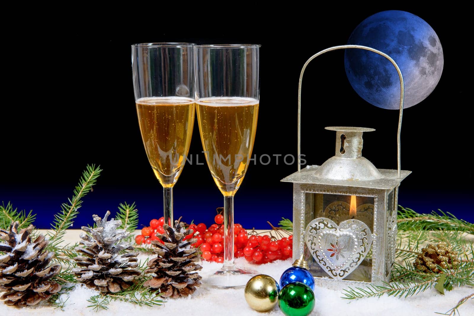 two glasses of champagne in a christmas decor, moon on background