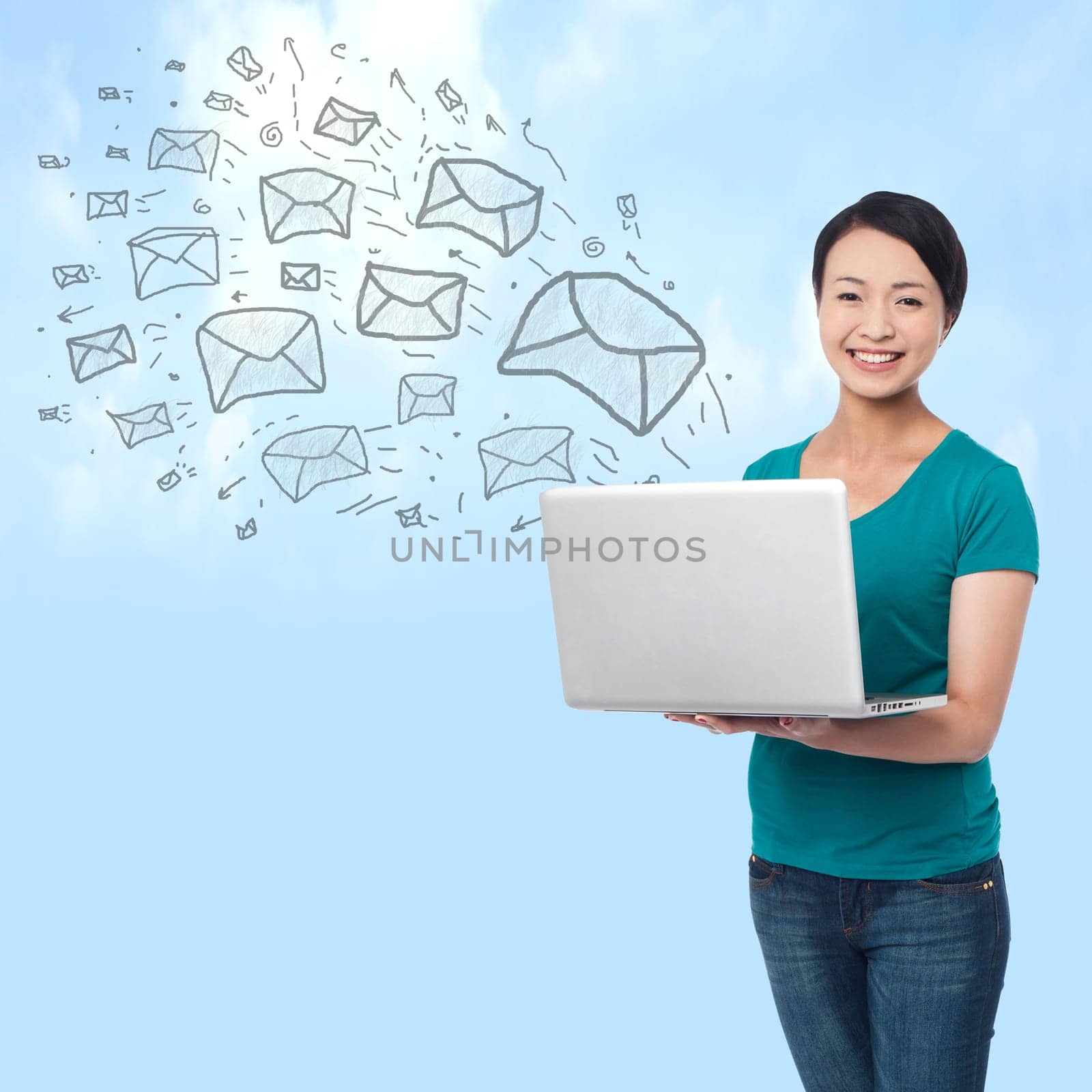 Pretty woman sending e-mails from a laptop, sky background