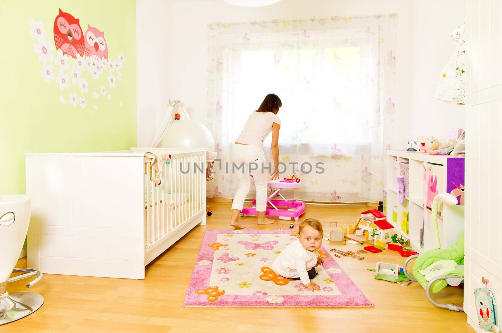 Young mother with baby in the nursery