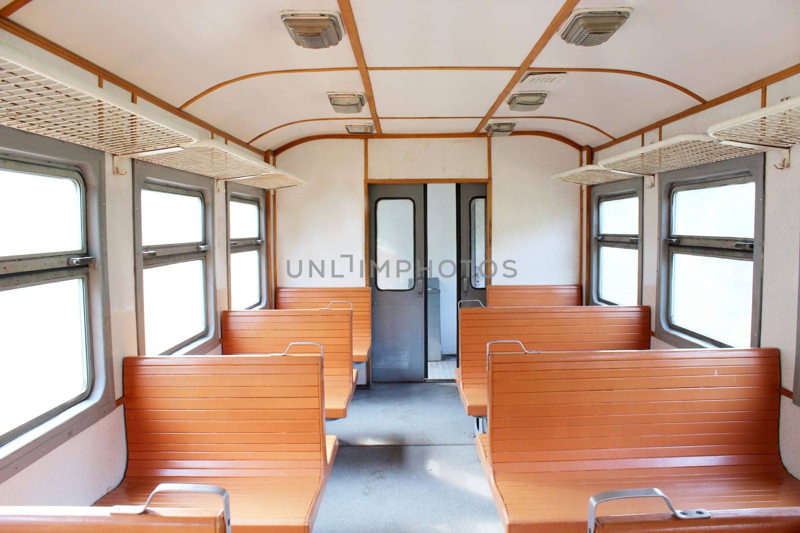 inside of carriage of electric train with wooden benches