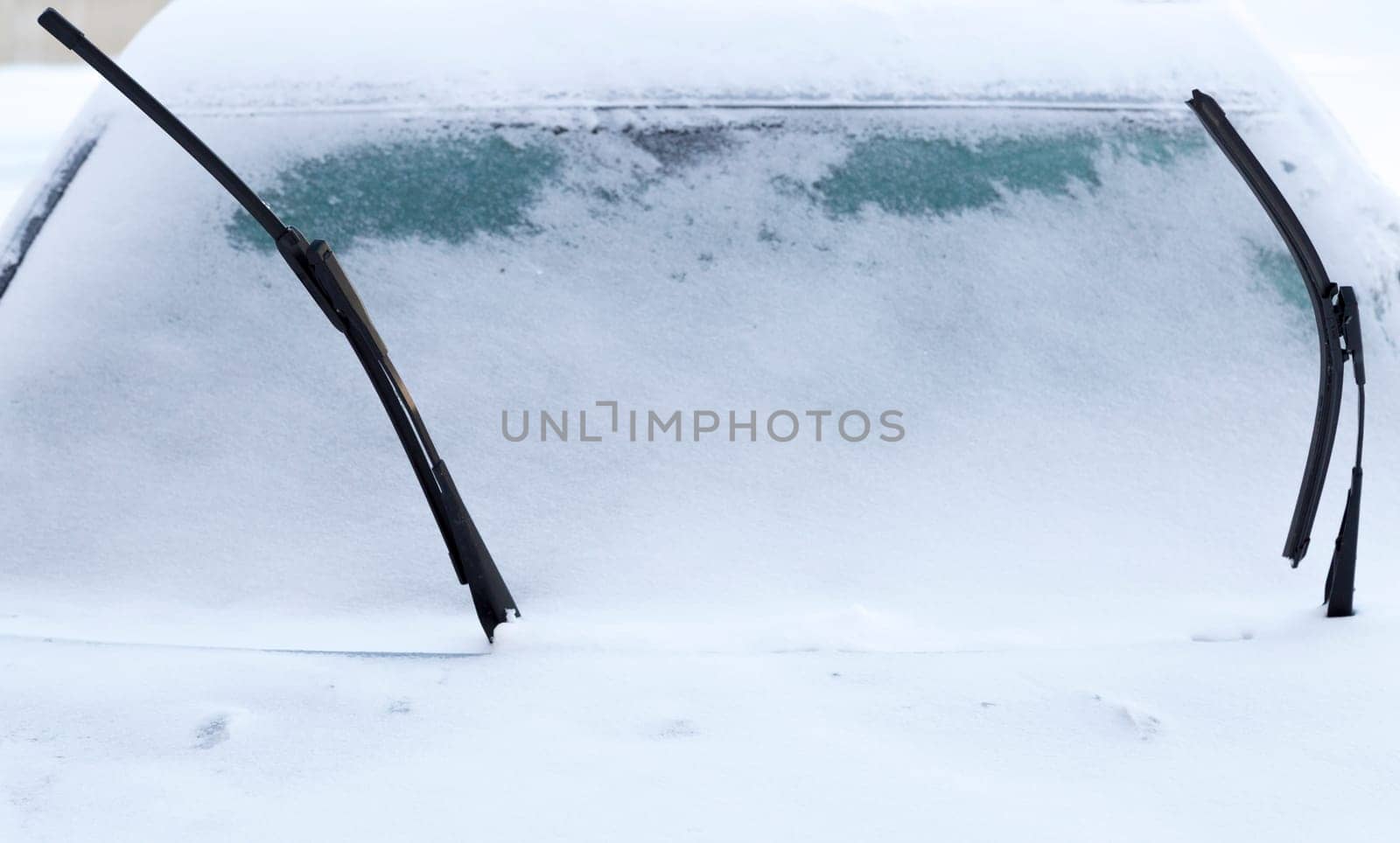 Windscreen Wipers on Snowy Car in winter time.