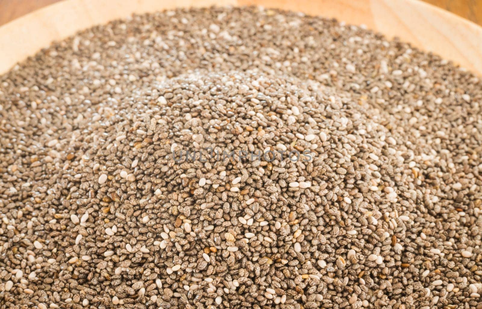 Nutritious chia seeds on a wooden plate, stock photo