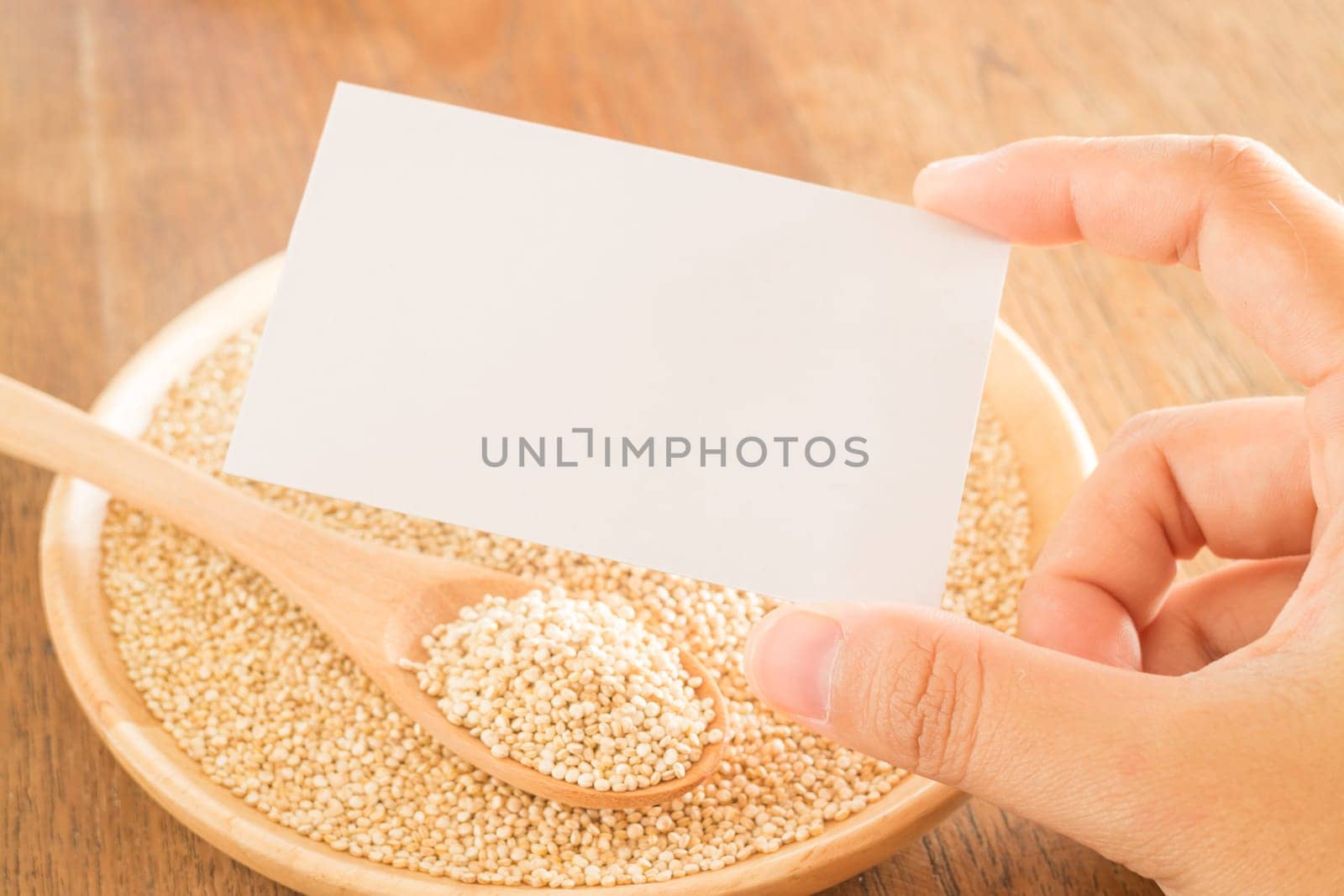 Organic quinoa grain and hand on business card, stock photo