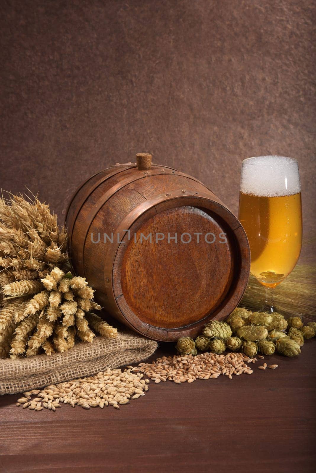Old wooden barrel with beer glass,wheat,barley,hops and malt