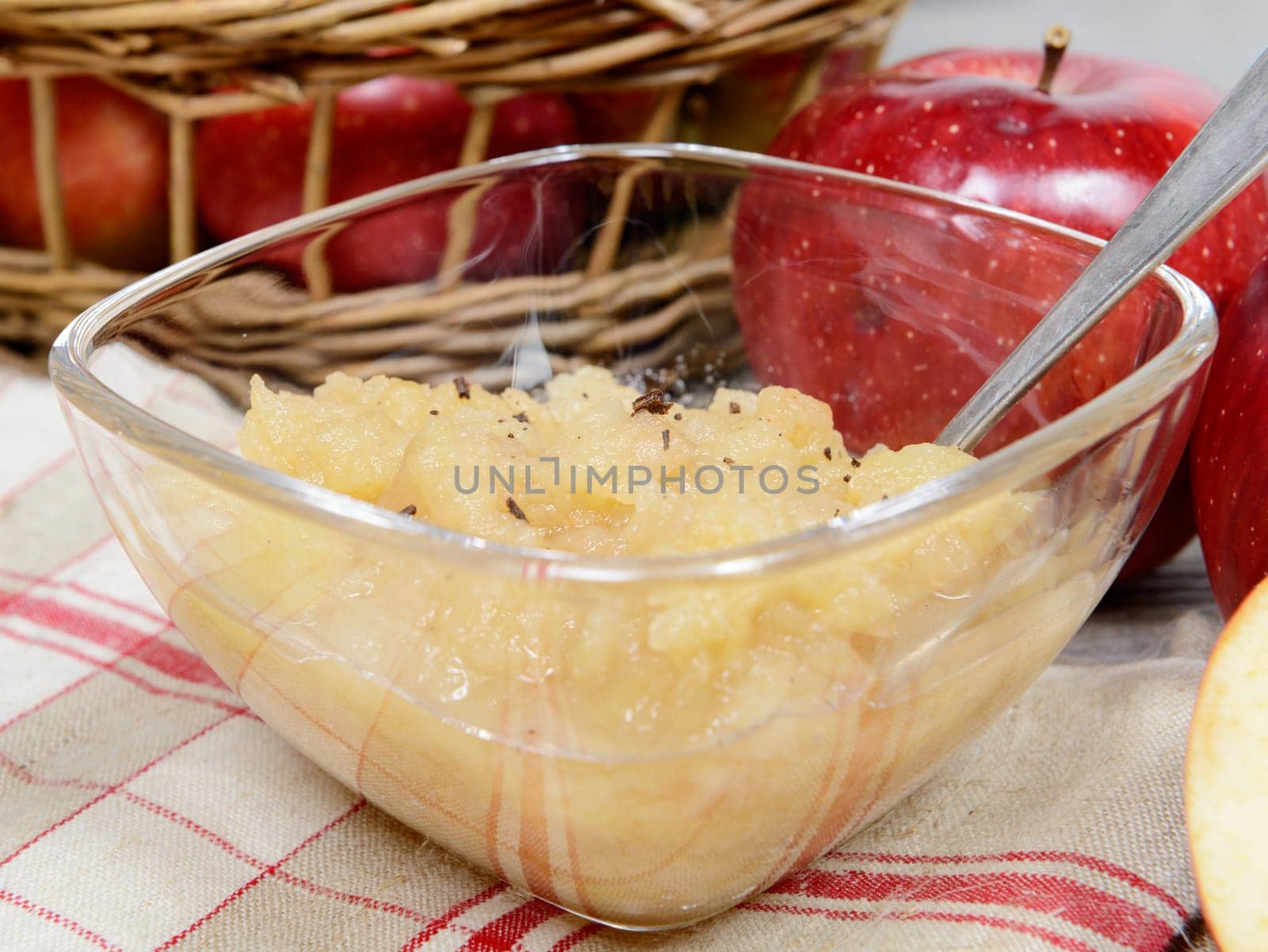 applesauce with some apples in a glass cup