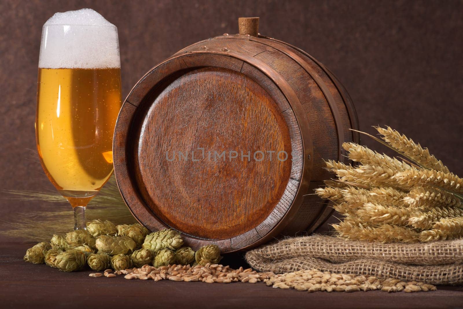 Old wooden barrel with beer glass,wheat,barley,hops and malt