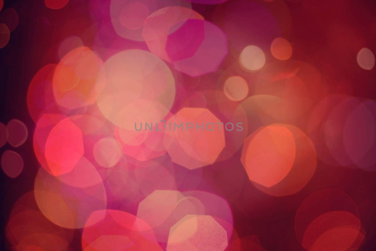 Defocused blur lights background, closeup in red color with bokeh effect. Ideal for holiday greeting card, event, or web backdrop.