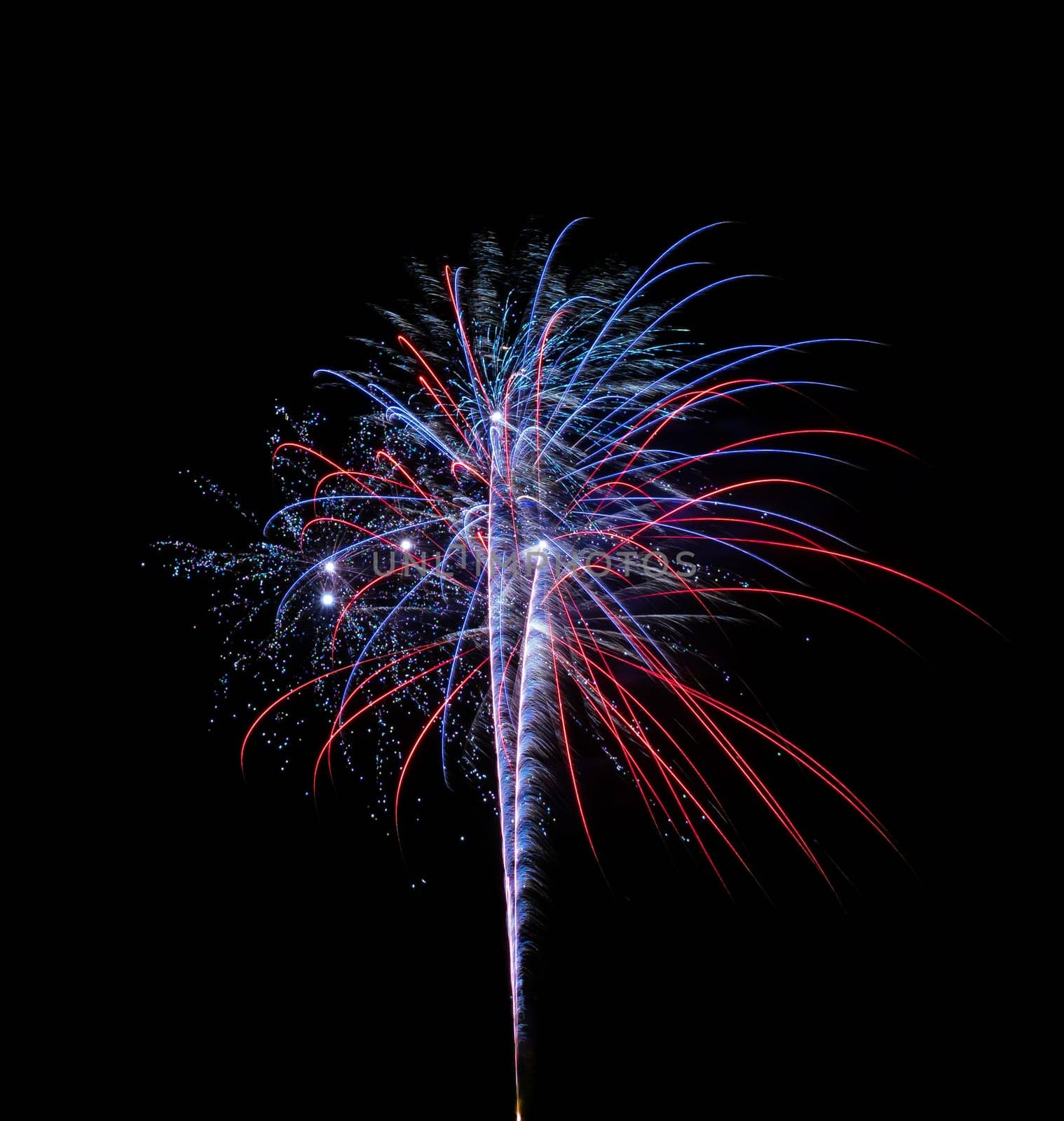 A single and colorful fireworks over a night sky isolated on black background