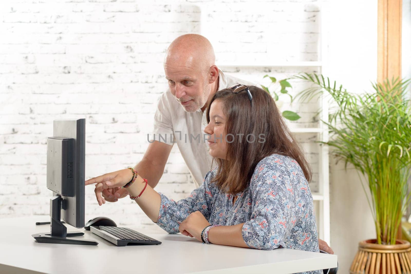 a man teacher and a student girl with a computer
