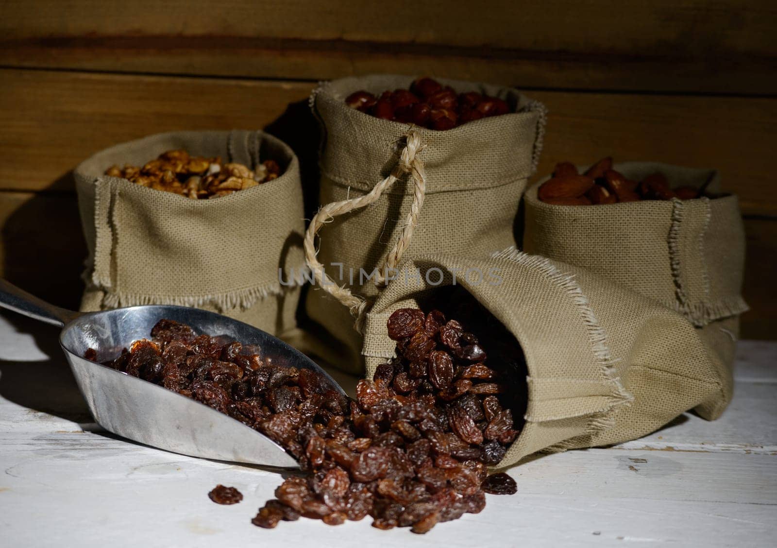 dried currants in a canvas bag on white wooden table