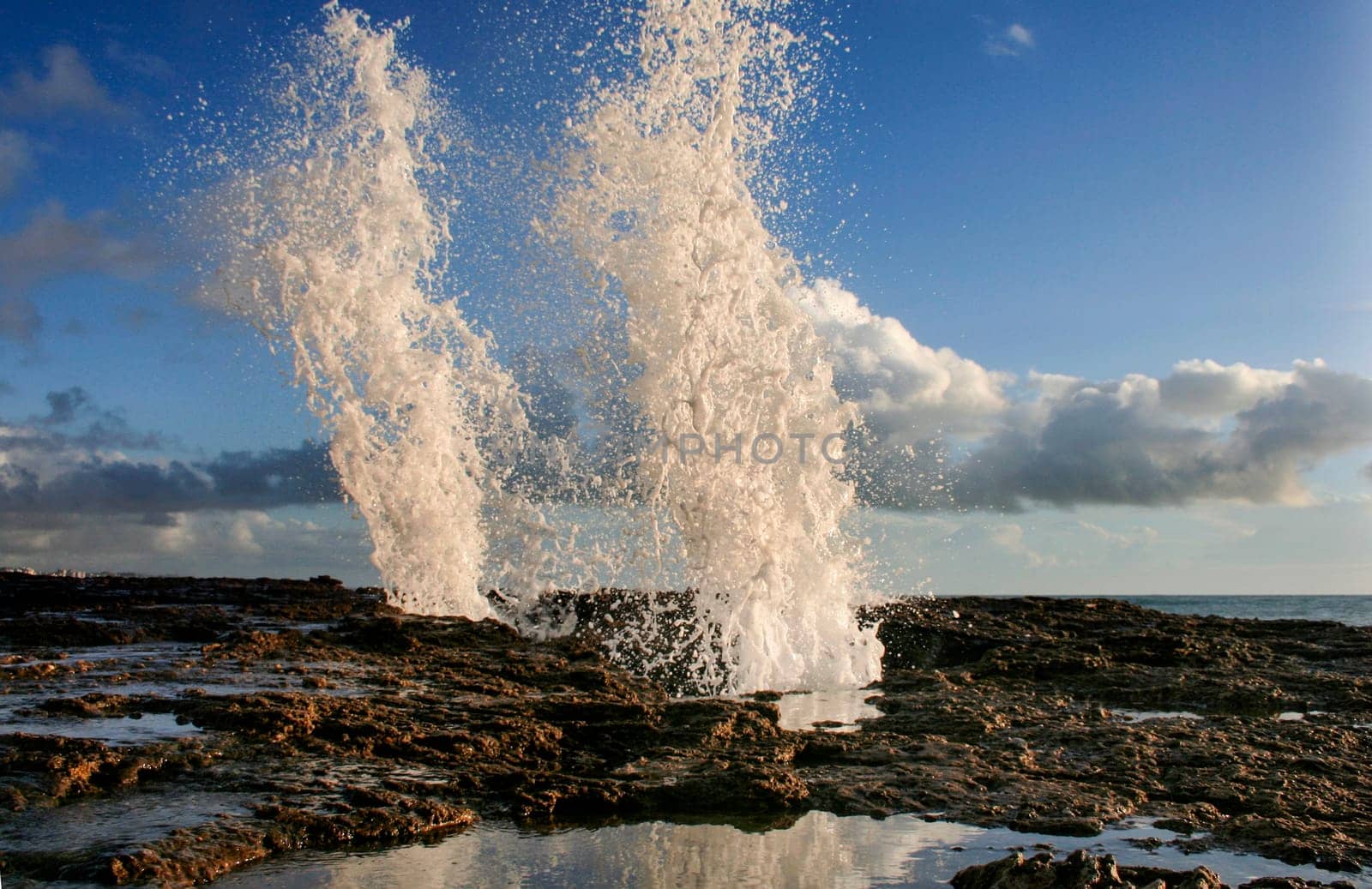 blow hole on Cadiz coastline sending two burst of water high into the air, Spain