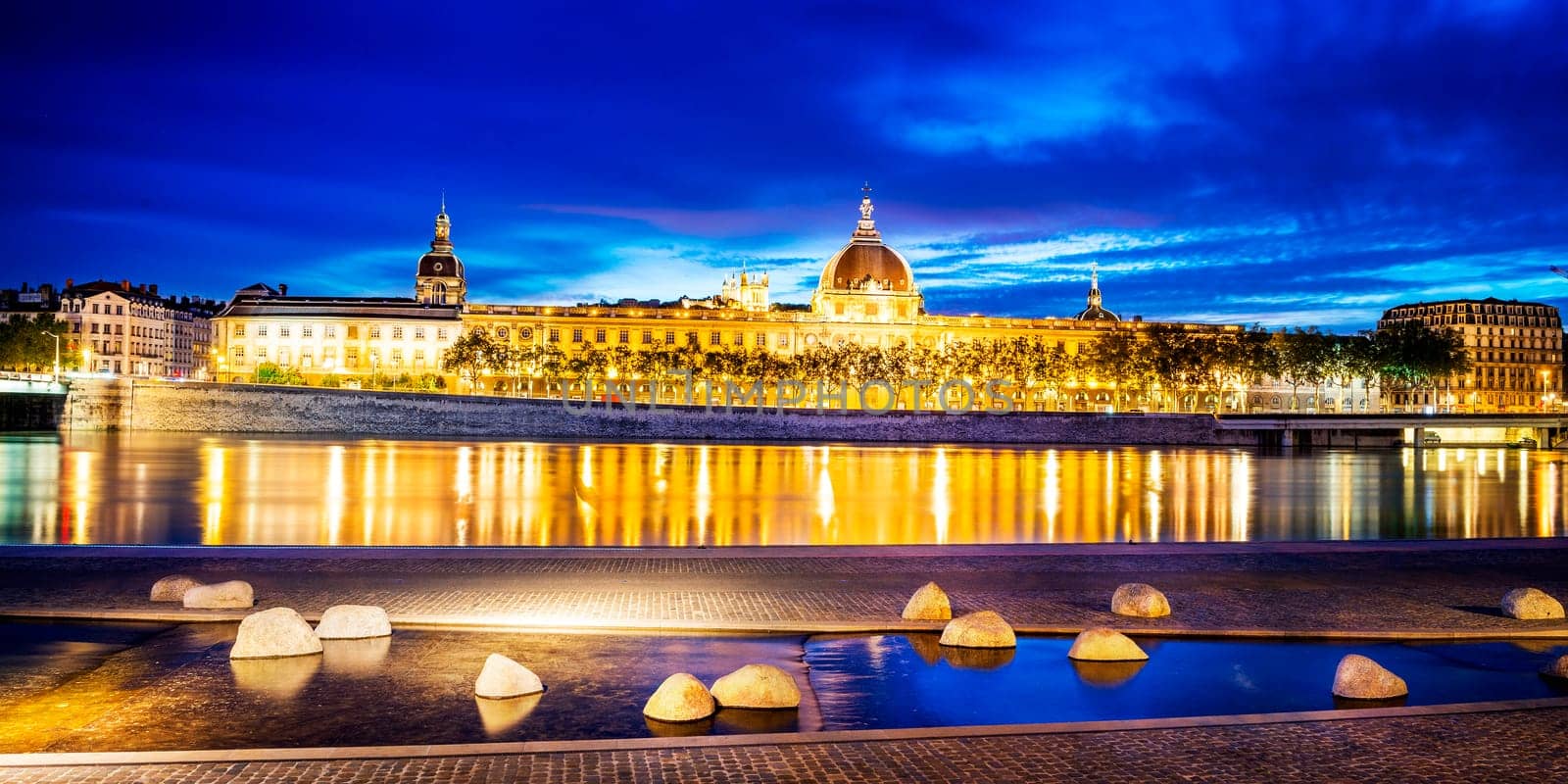 night view from Rhone river in Lyon city with Hotel Dieu and Fourviere cathedral, France