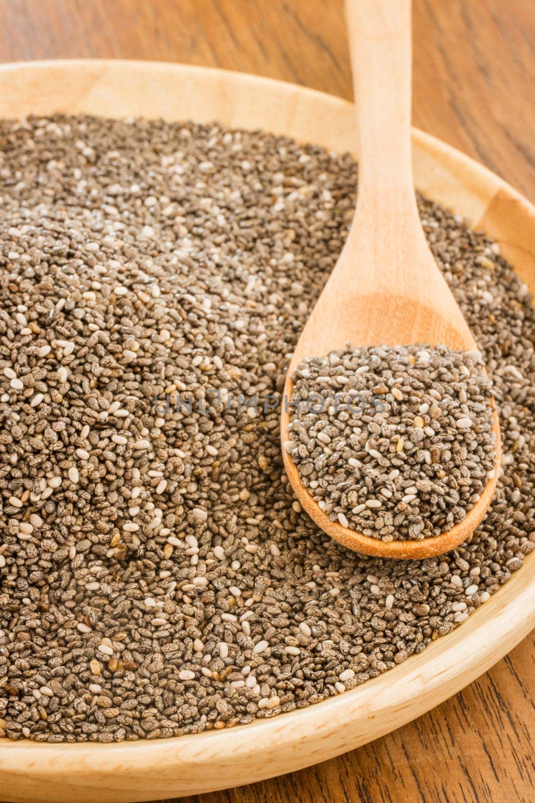 Nutritious chia seeds on a wooden plate, stock photo