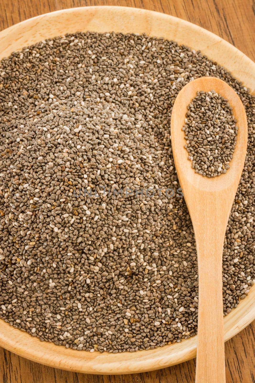 Nutritious chia seeds on a wooden plate, stock photo