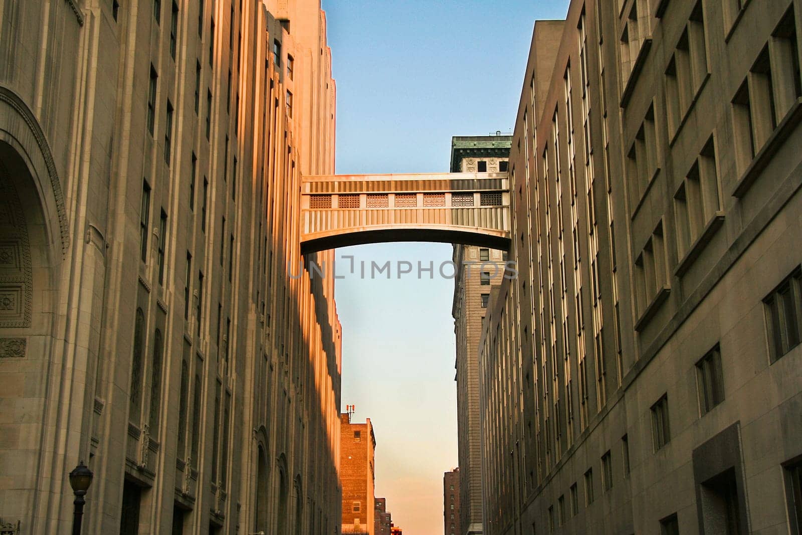 A walkway connecting two office buildings high above the street. Sunset