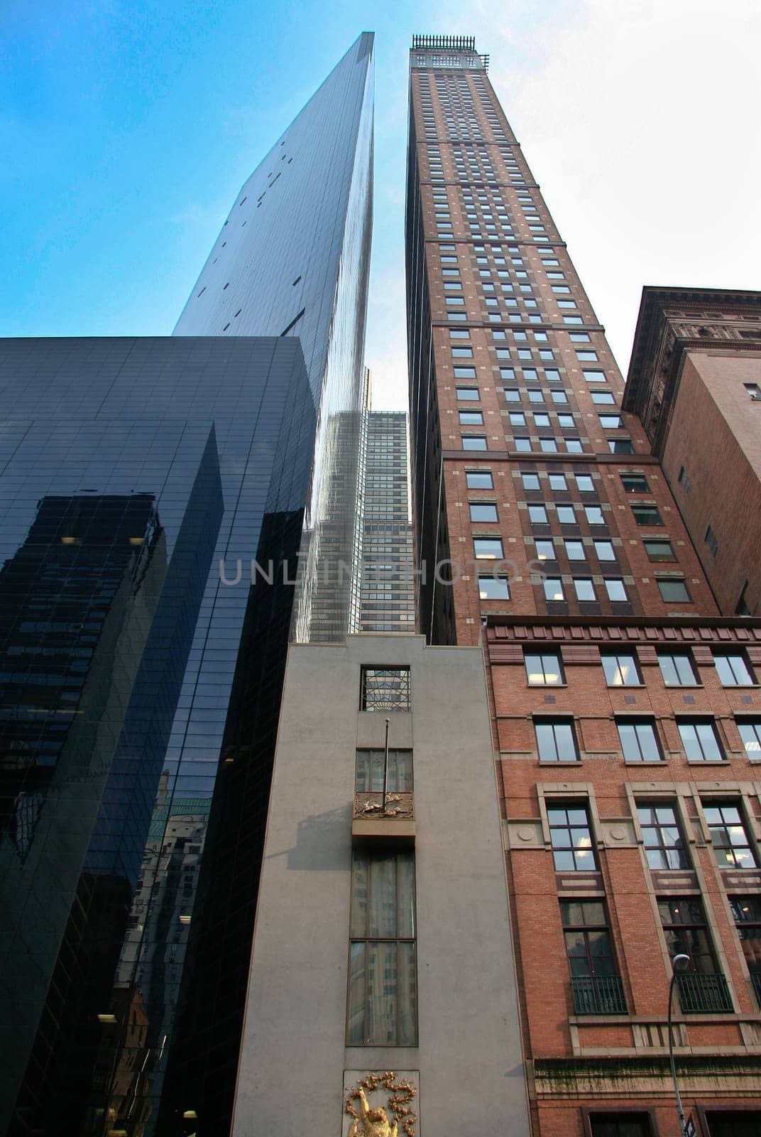 Two skyscrapers of different materials are proudly standing under the New York sun