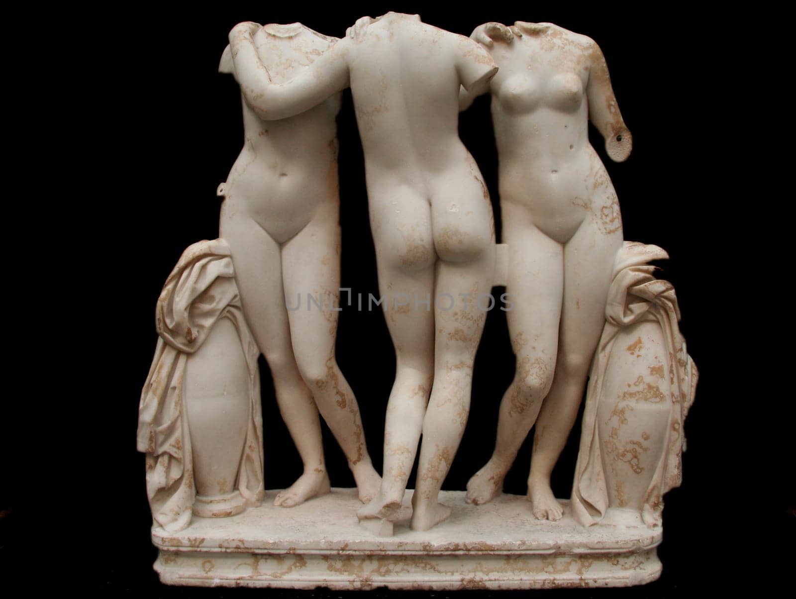 Classic white marble statue of Three Graces, isolated on black background
