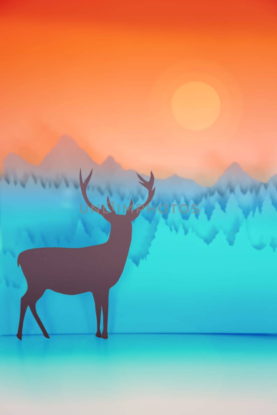 Paper cut handmade winter holiday illustration with deer in forest and sunset sky background. Ideal for Christmas greeting card, New Year, poster or campaign.