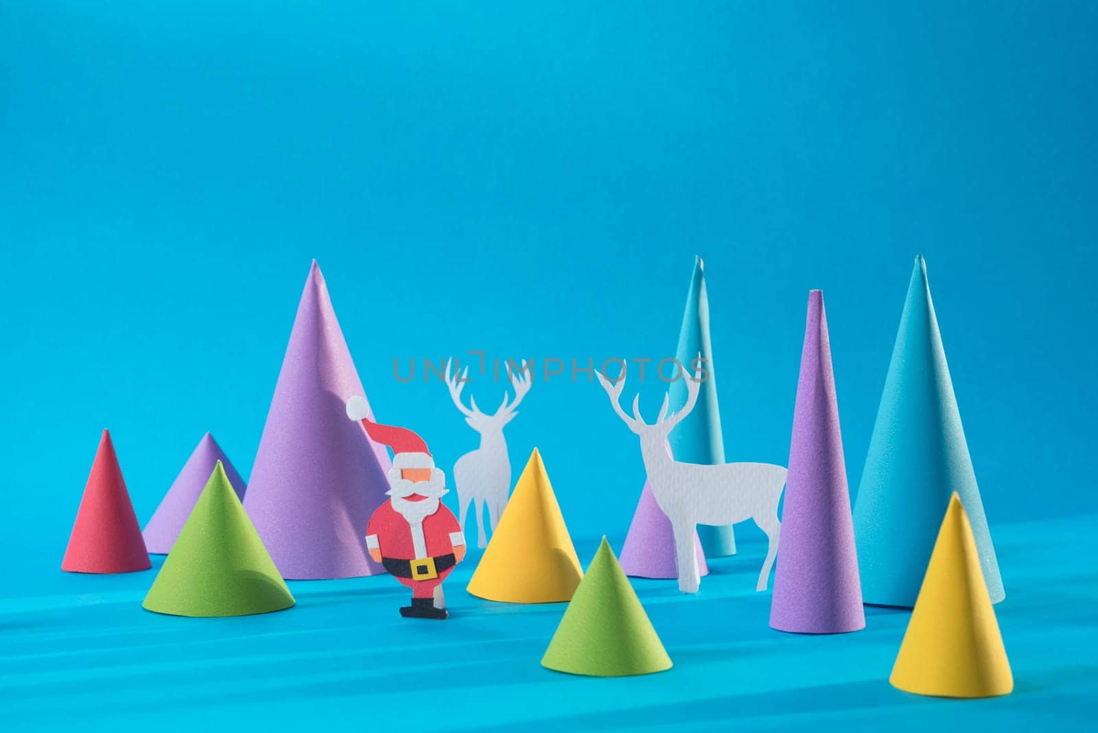 Christmas handmade 3d paper cut santa with deers and colorful pine tree shapes. Ideal for xmas greeting card, holiday poster or web.