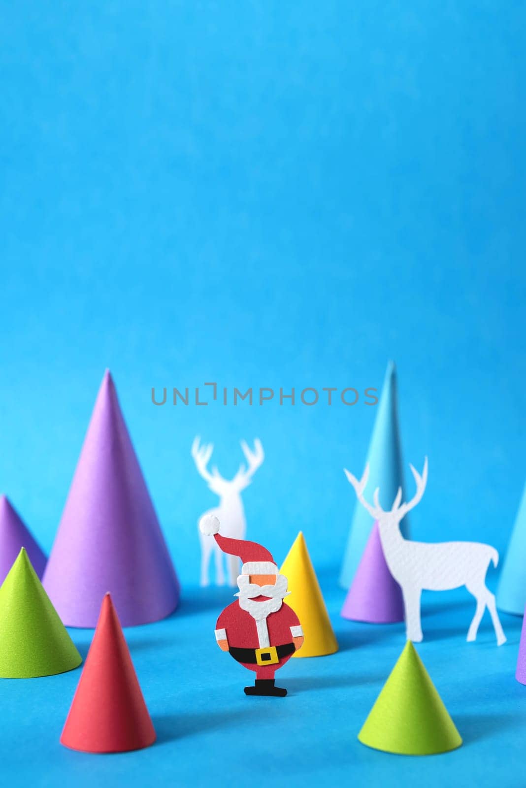 Christmas colorful paper craft scene with santa, deer silhouettes and xmas pine tree shapes, includes copy space. Ideal for holiday greeting card, poster or web.