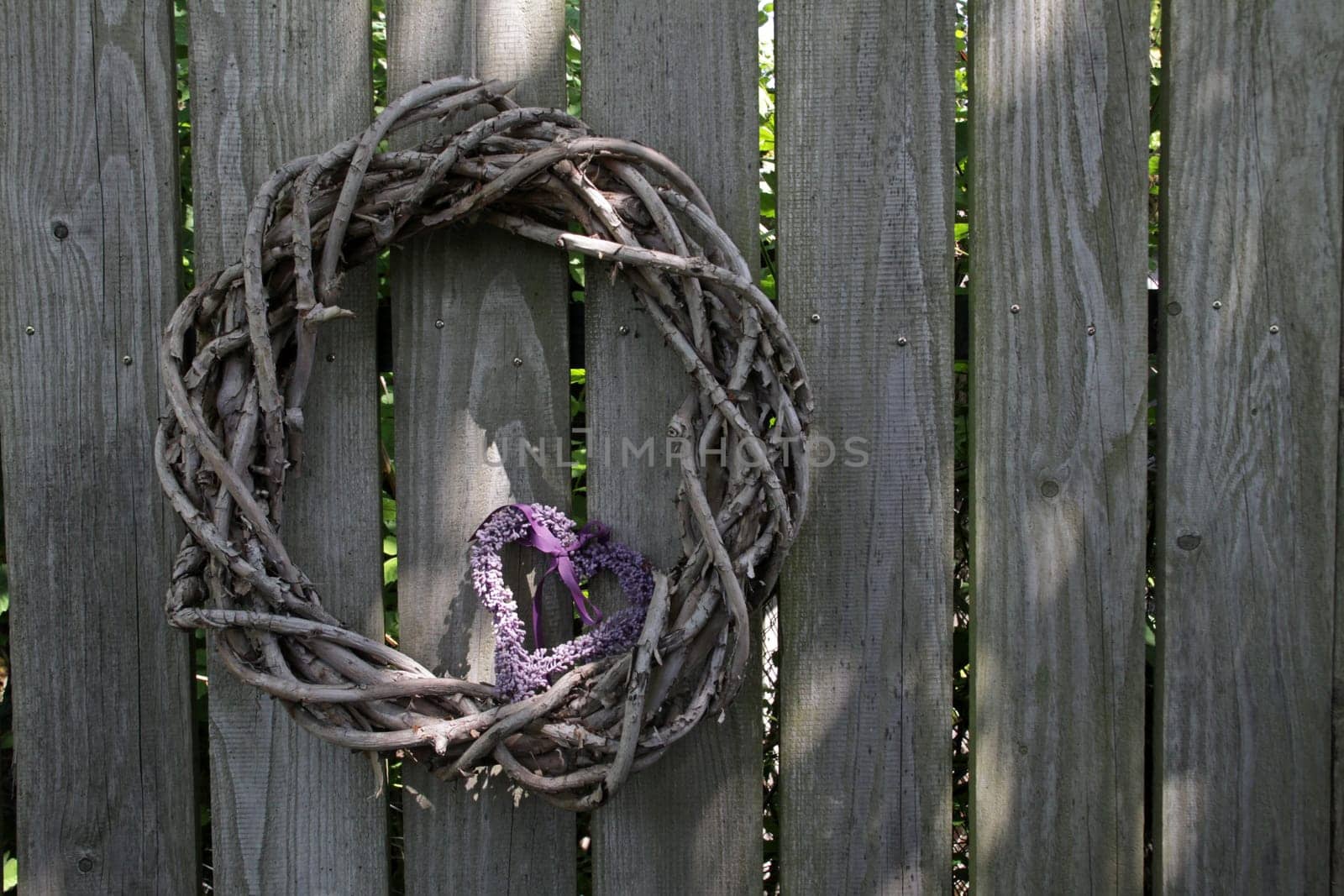 Wooden wreath with heart on a wooden fence