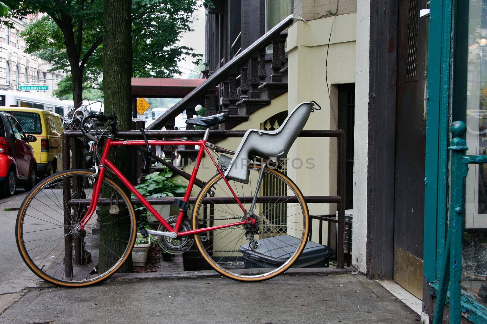 Red Bike with baby chair parked on one sidewalks of New York City