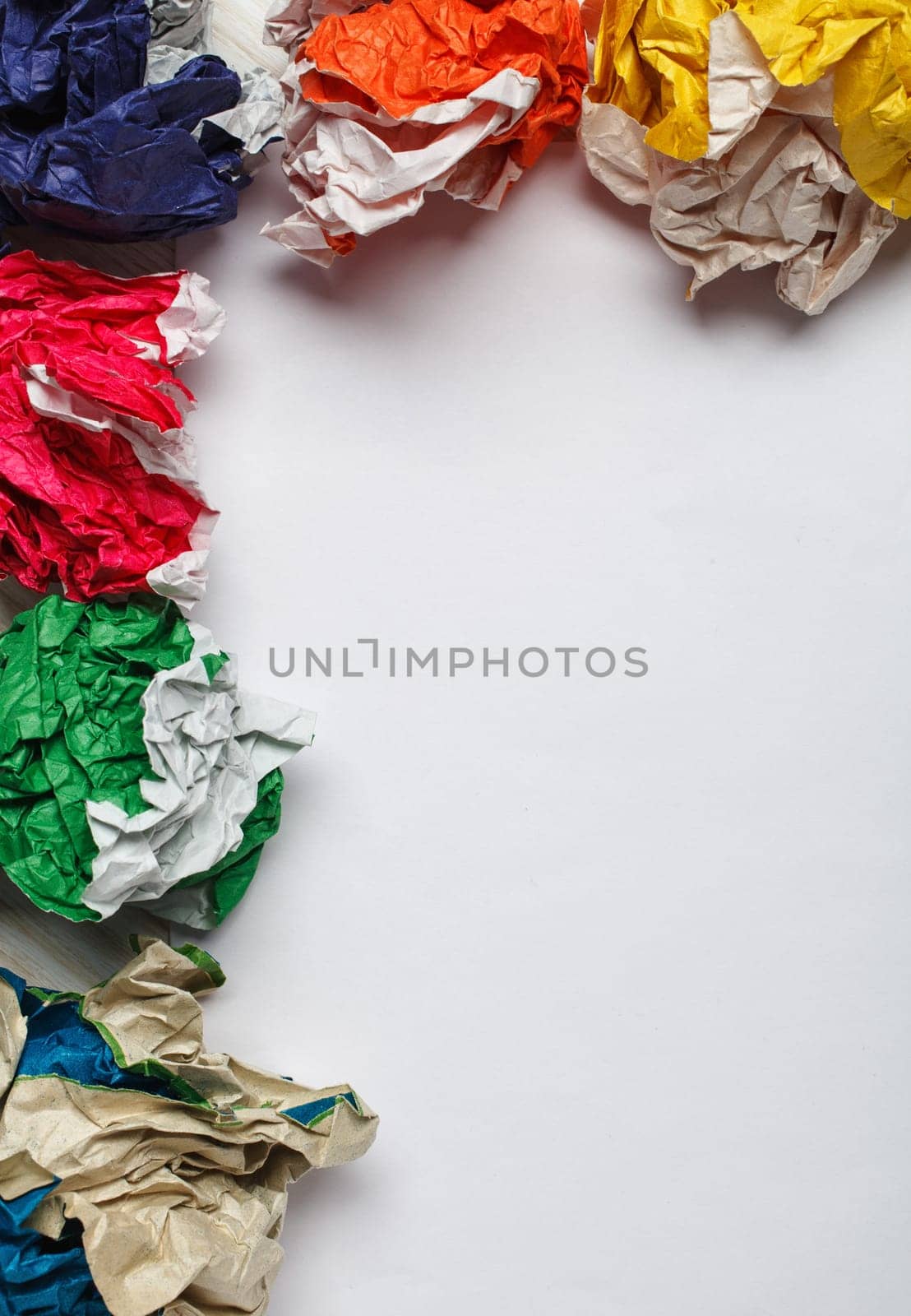 crumpled colorful paper and white paper card  on wooden background, place for tex