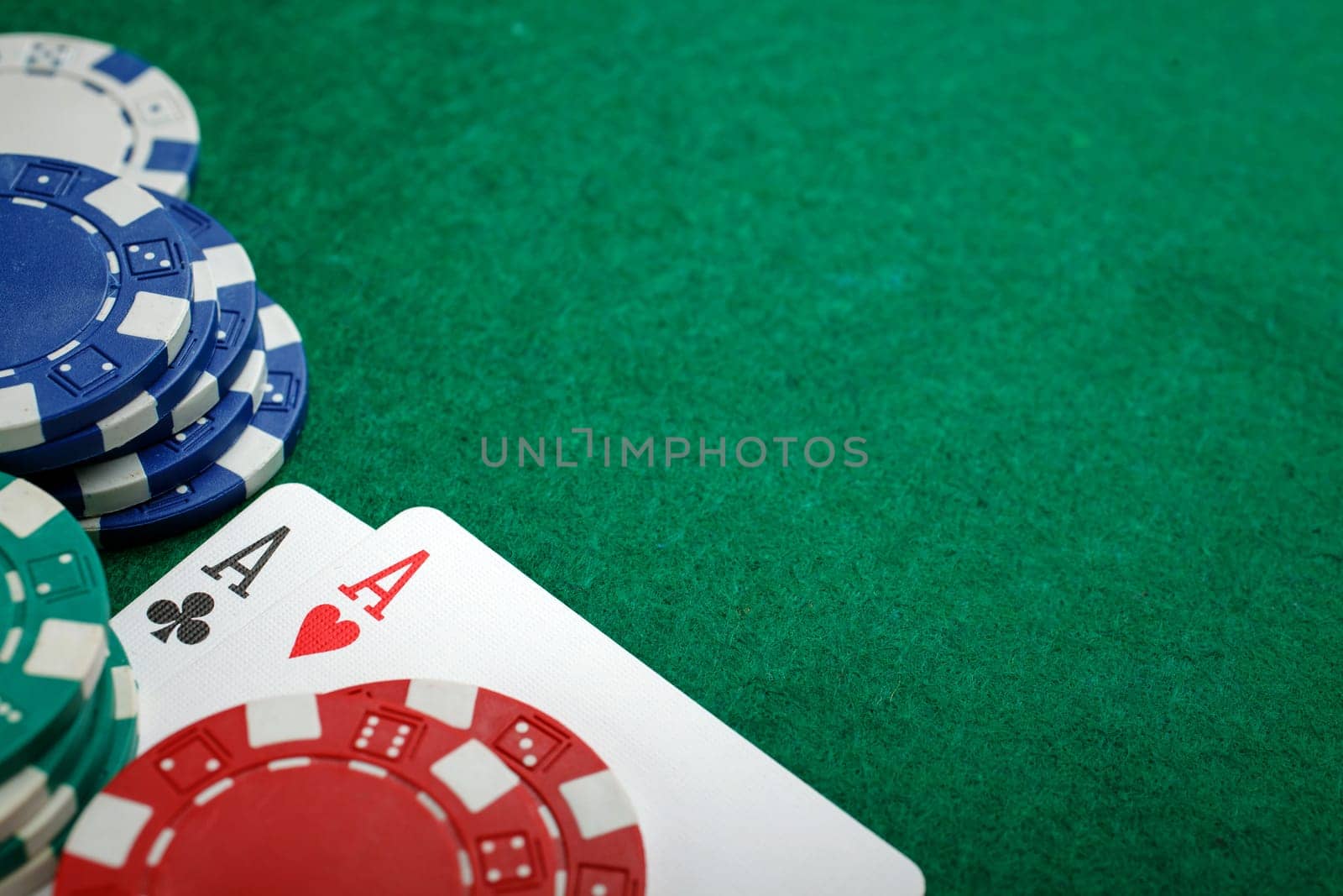 Stack of chips and two aces on the table on the green baize - poker game concept