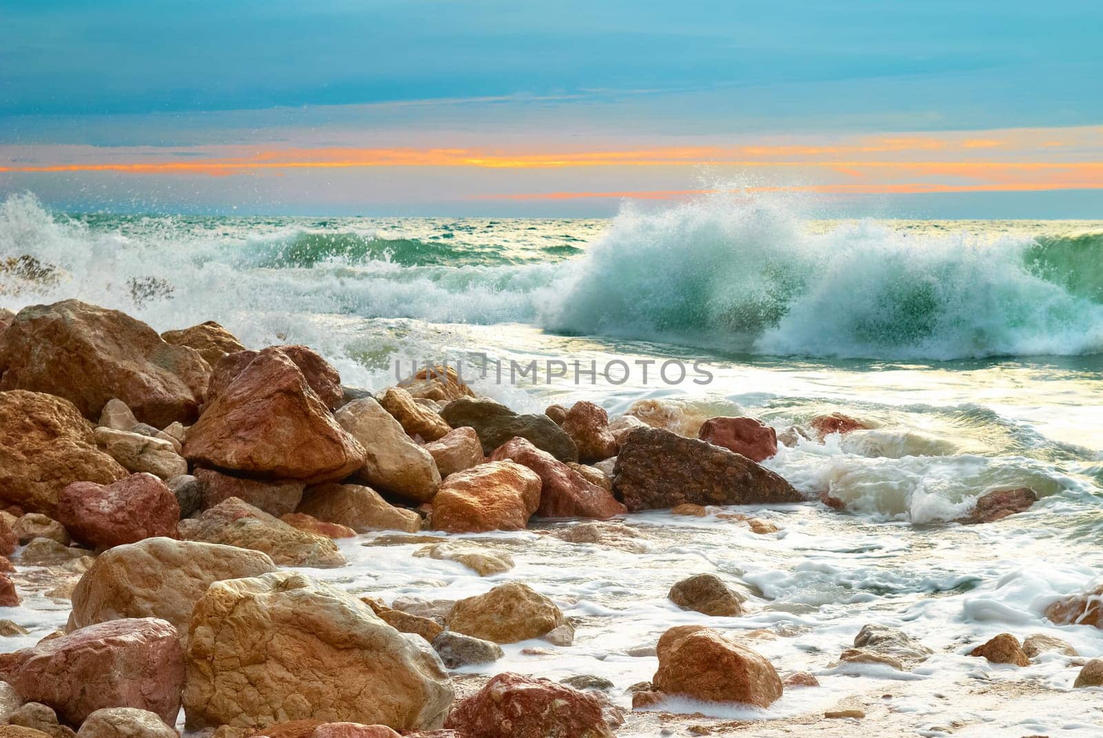 Sea landscape with waves on the beach against sunset