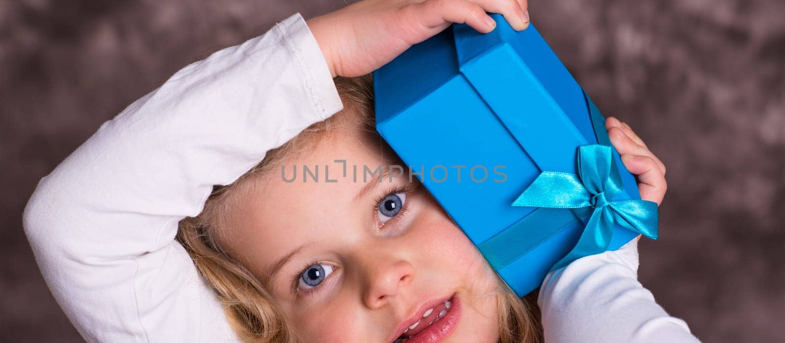 portrait of a sweet blond girl with blue present