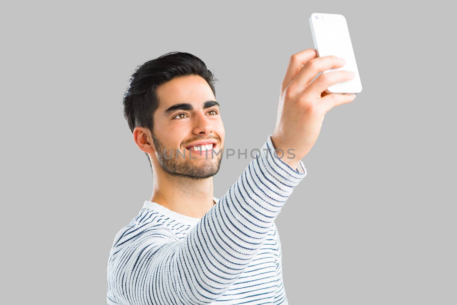 Young man sending a text message, isolated on white background