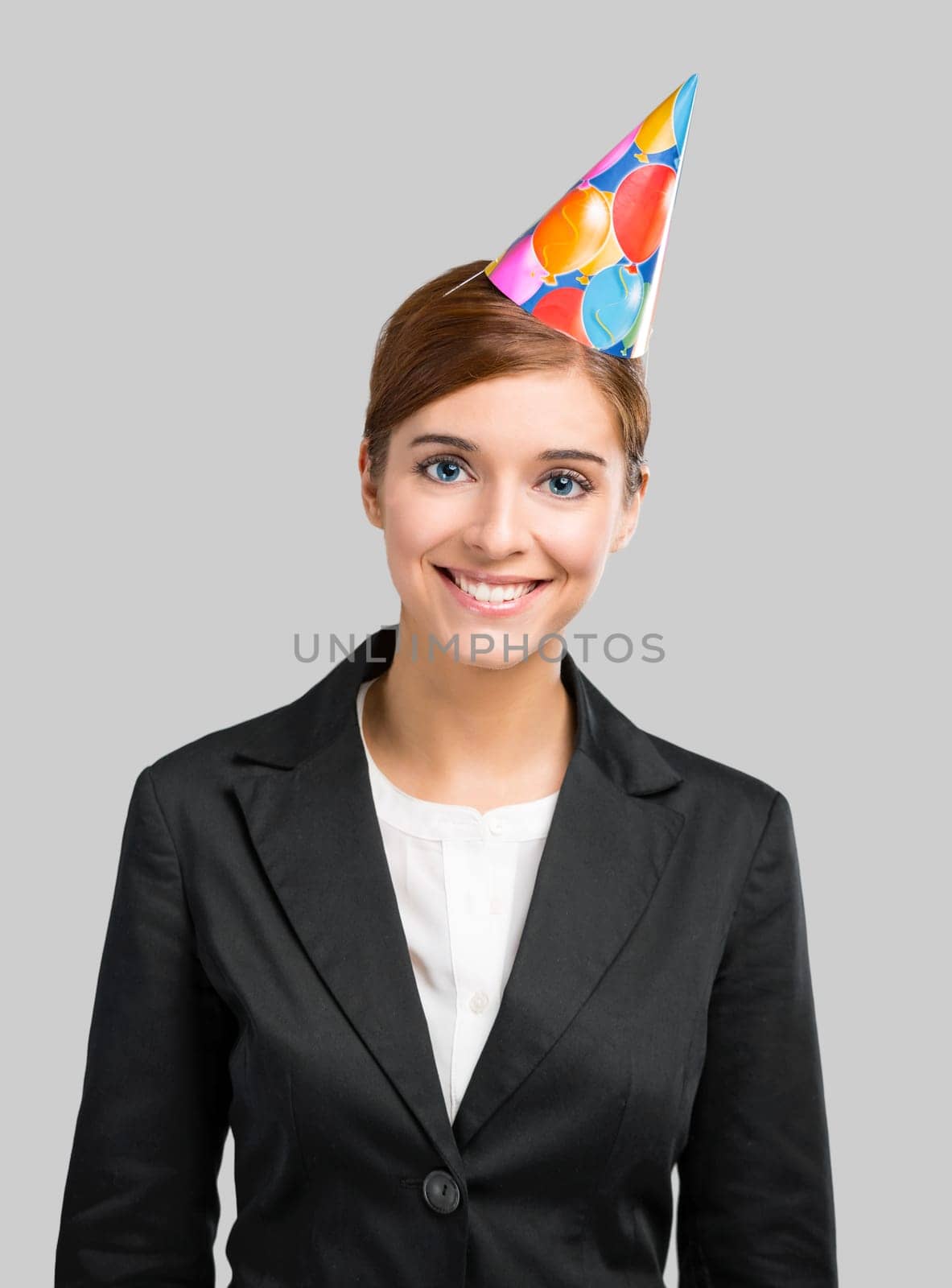 Portrait of a business woman celebrating something with a birthday hat on the head