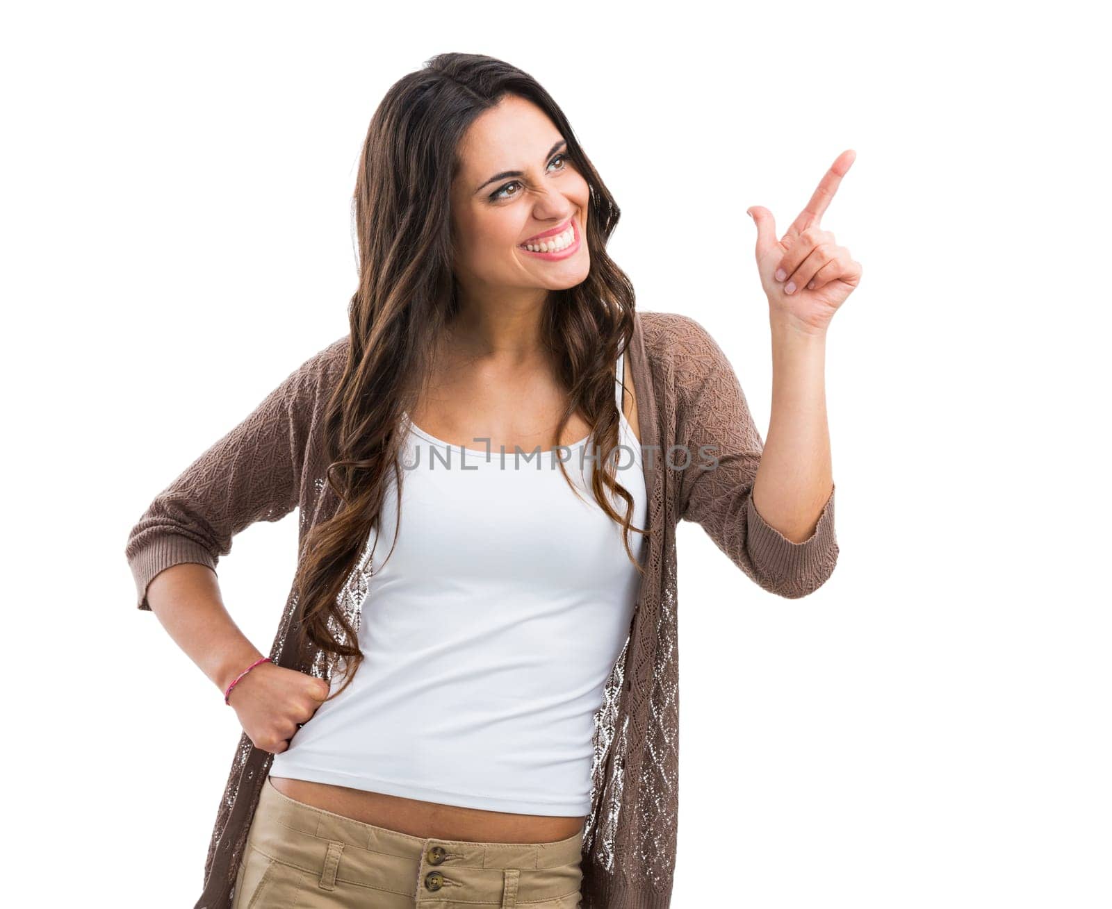 Beautiful brunette woman laughing and pointing to the left, isolated over white background