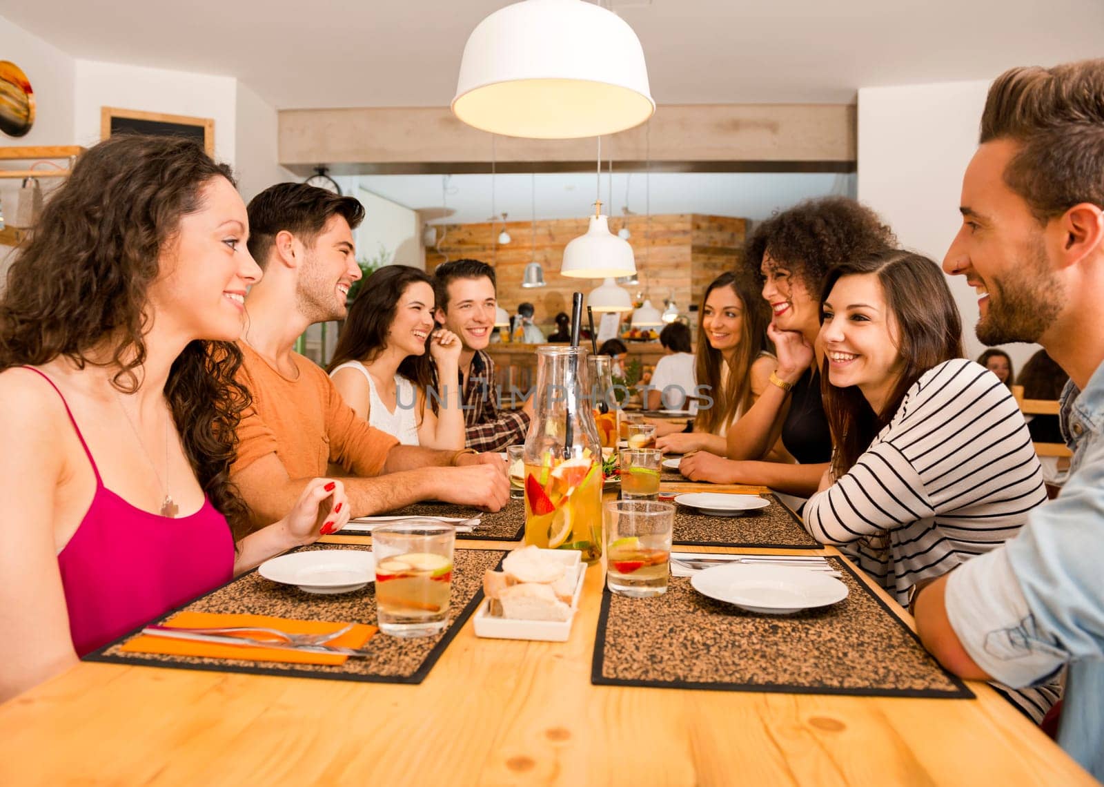 Multi-Ethnic Group of happy friends lunching and tasting the dessert at the restaurant