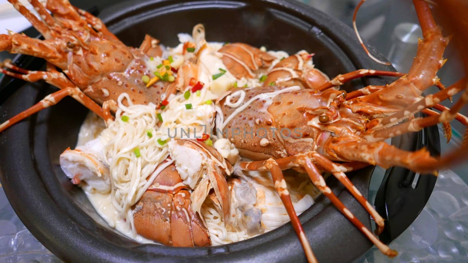 Homemade lobster noodles with cheese in the black bowl