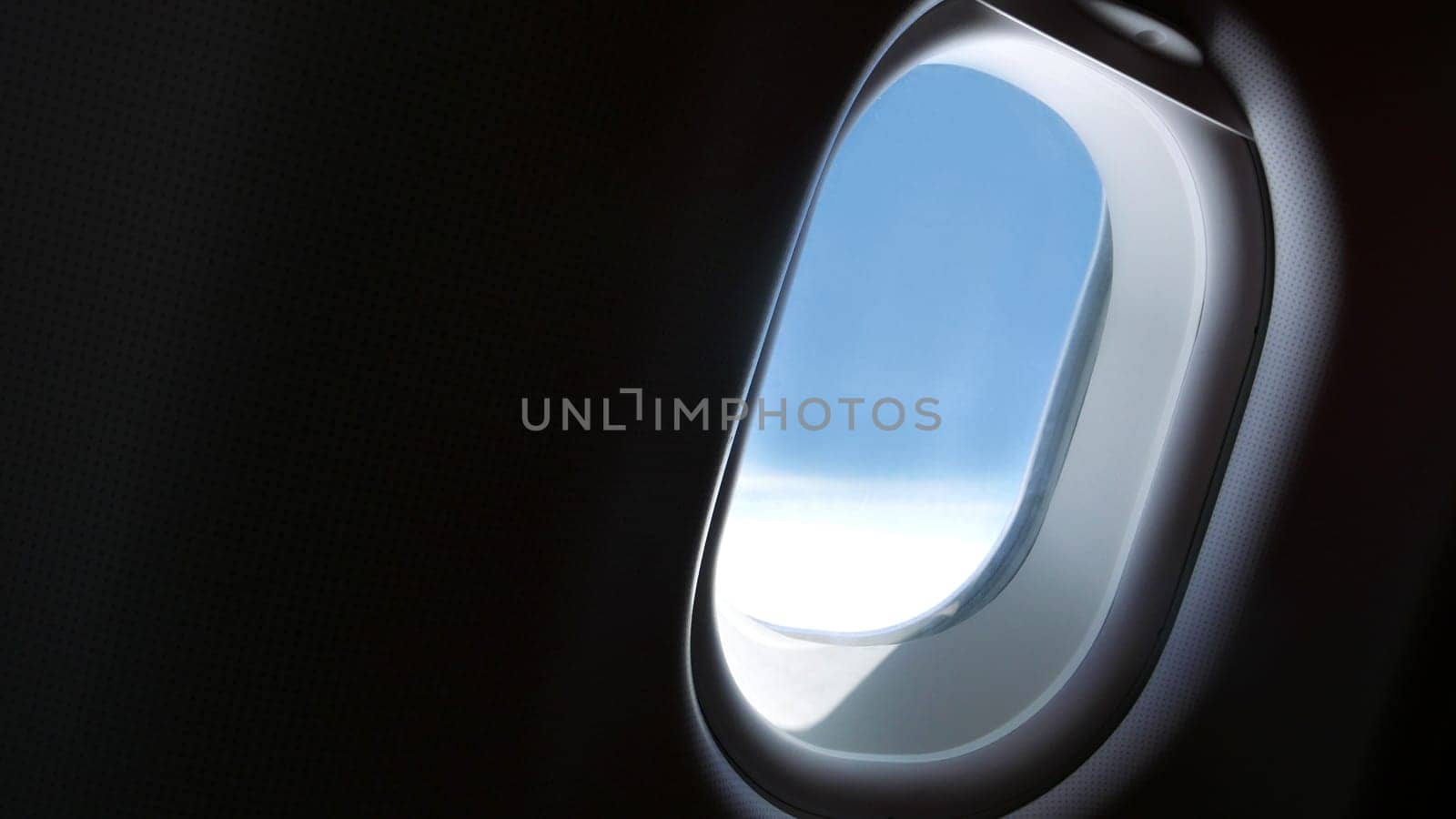 Airplane window with blue sky