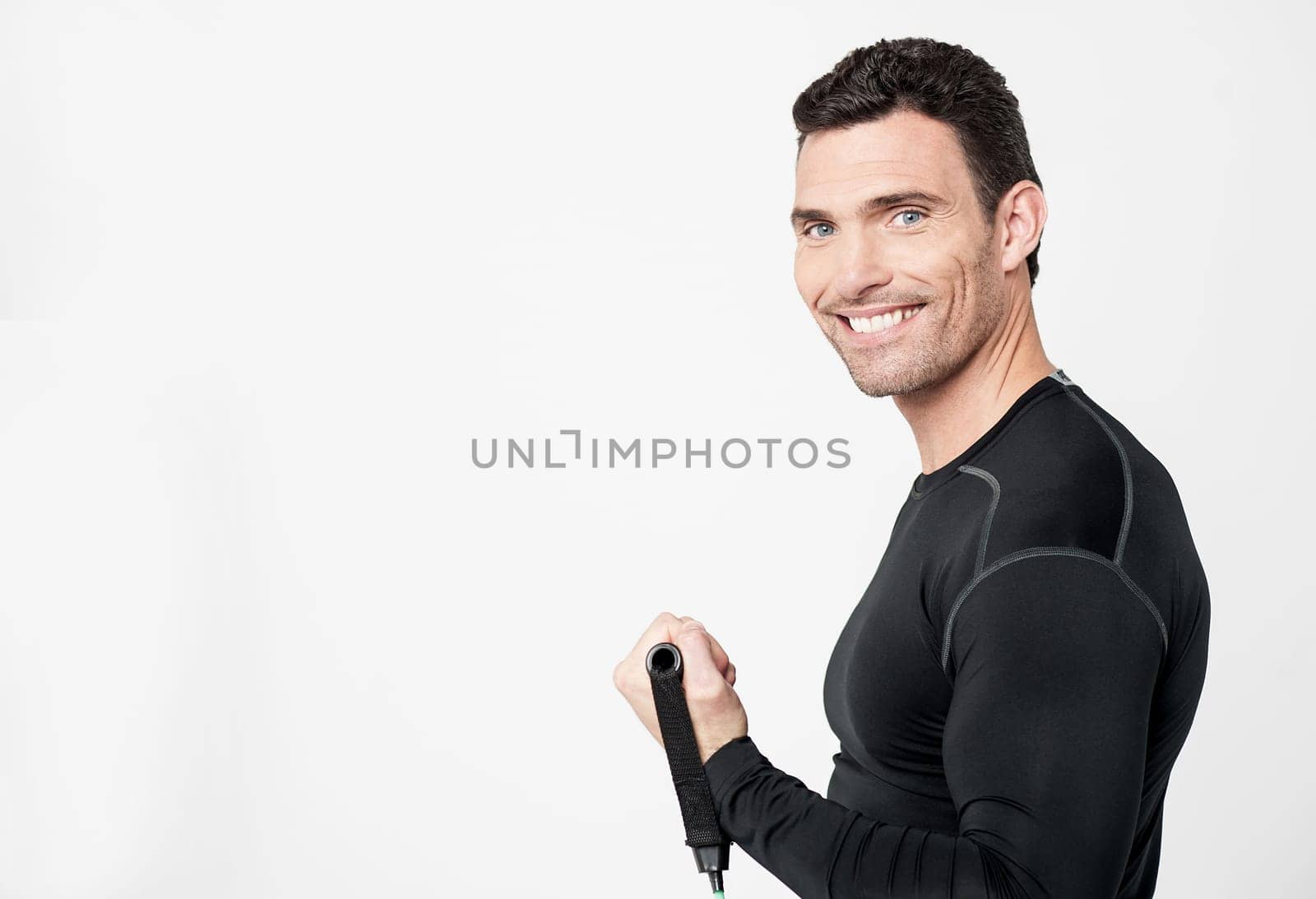 Side pose of a male exercising with stretching band