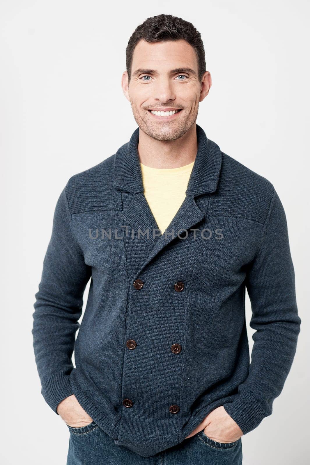 Smiling middle aged man posing with his hands in pockets