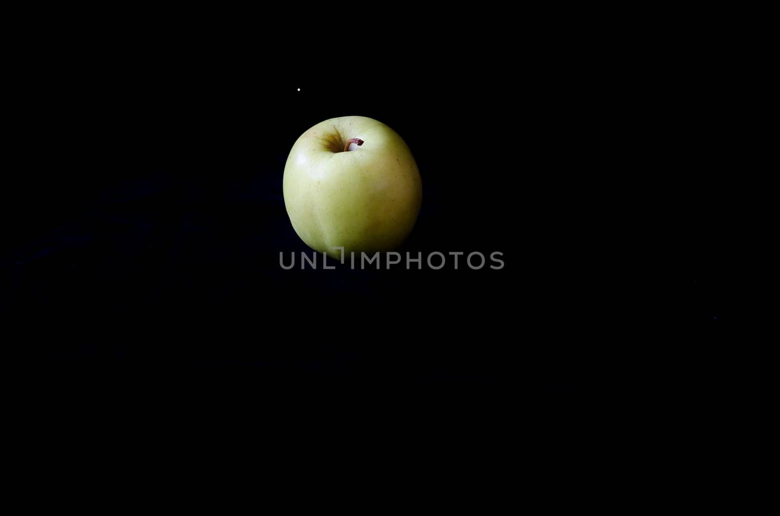 one green apple on a black background fresch and healty