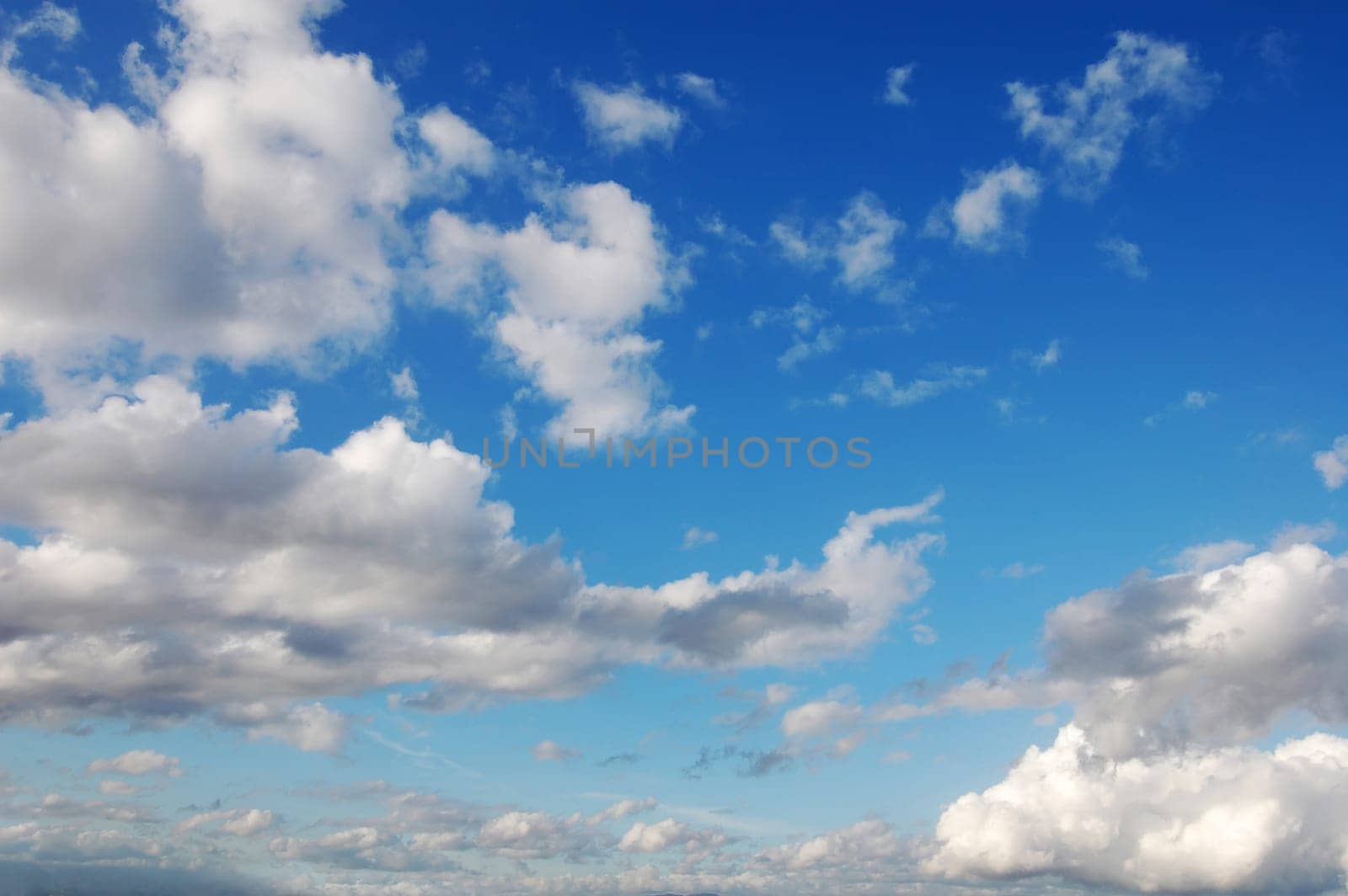 Blue sky with several cumulus white clouds.