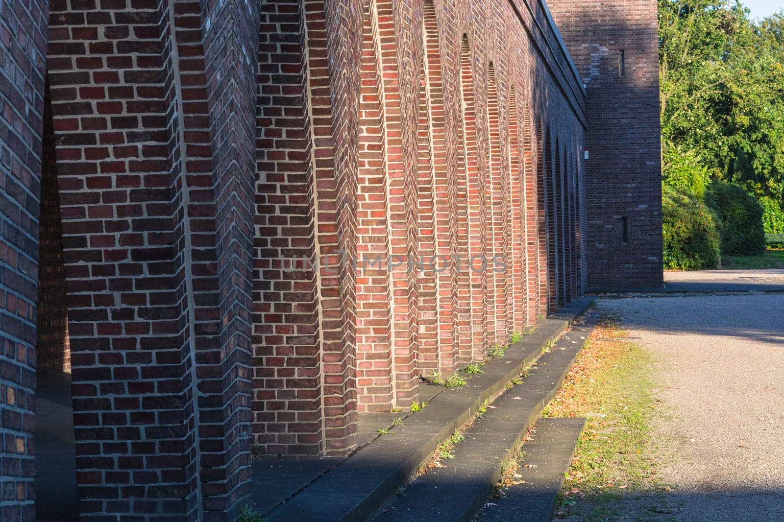 Old building with brick arches along a street.