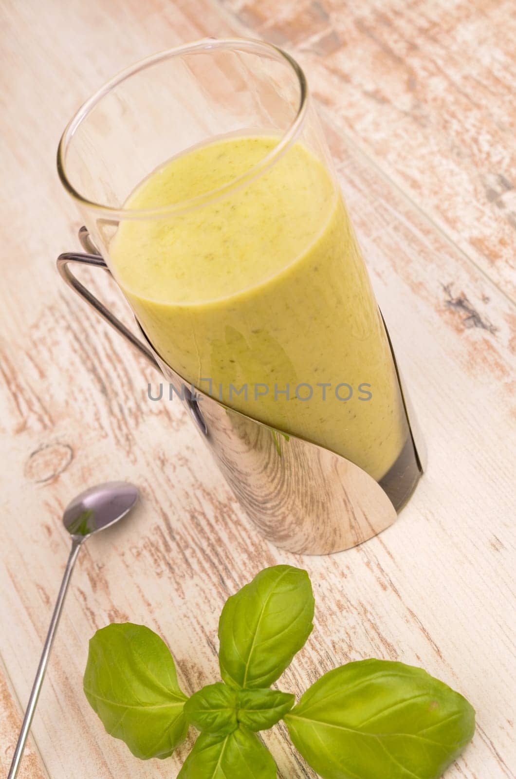 Green healthy smoothie on a rustic wooden table