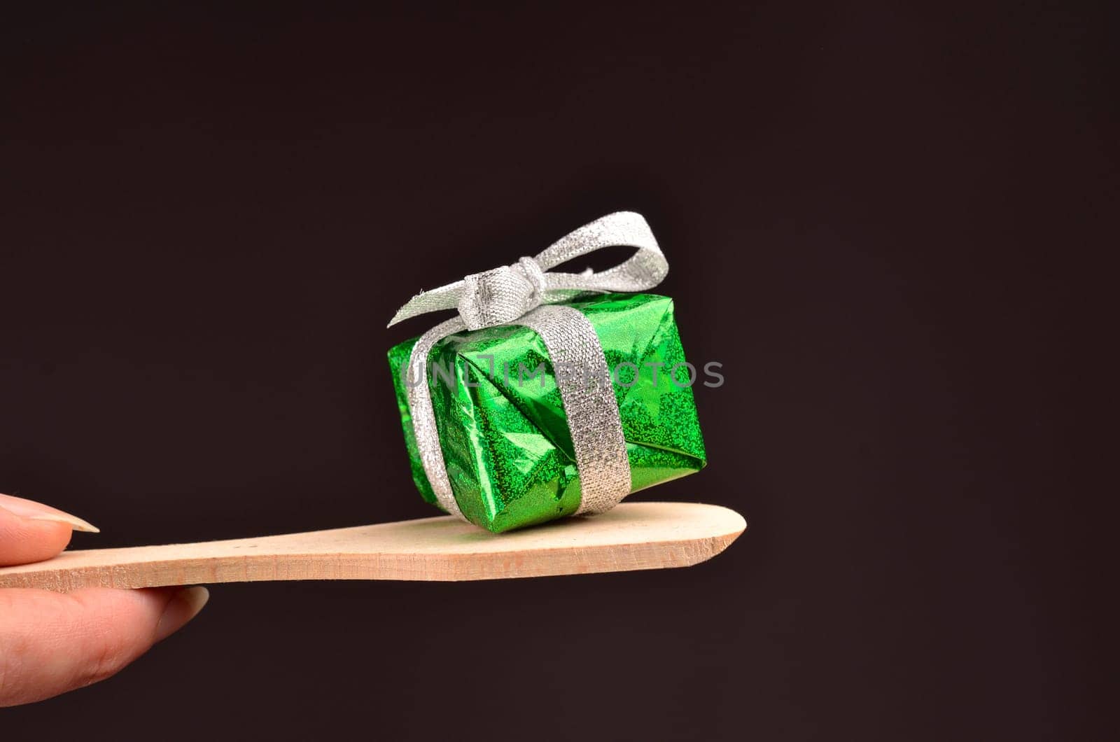 Green Christmas gift box with a bow on a dark background