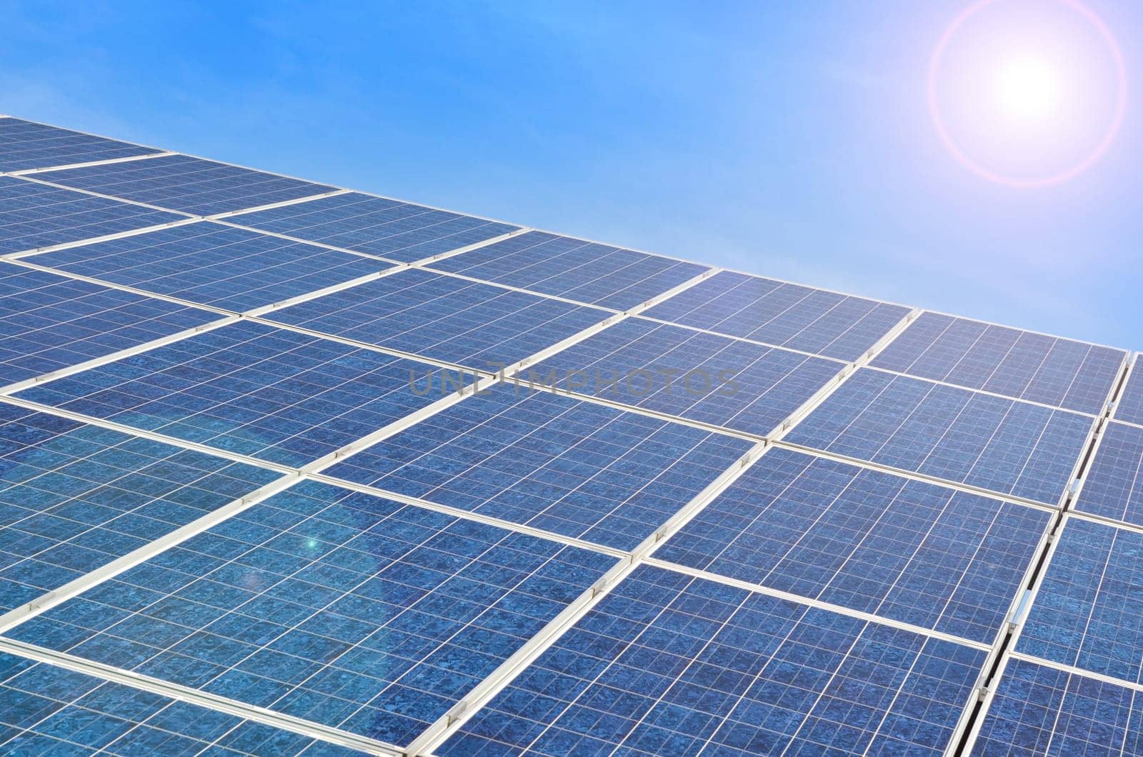 Solar panel with bright sun on blue sky