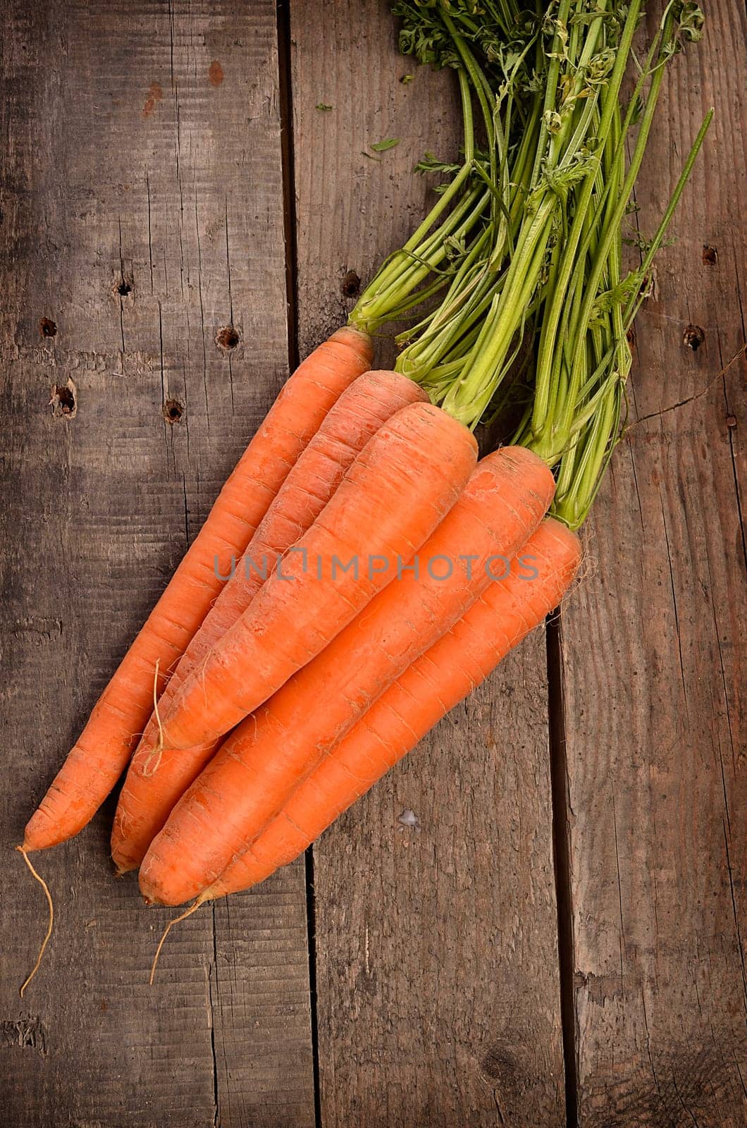 Fresh organic carrots on a rustic wooden background, top view