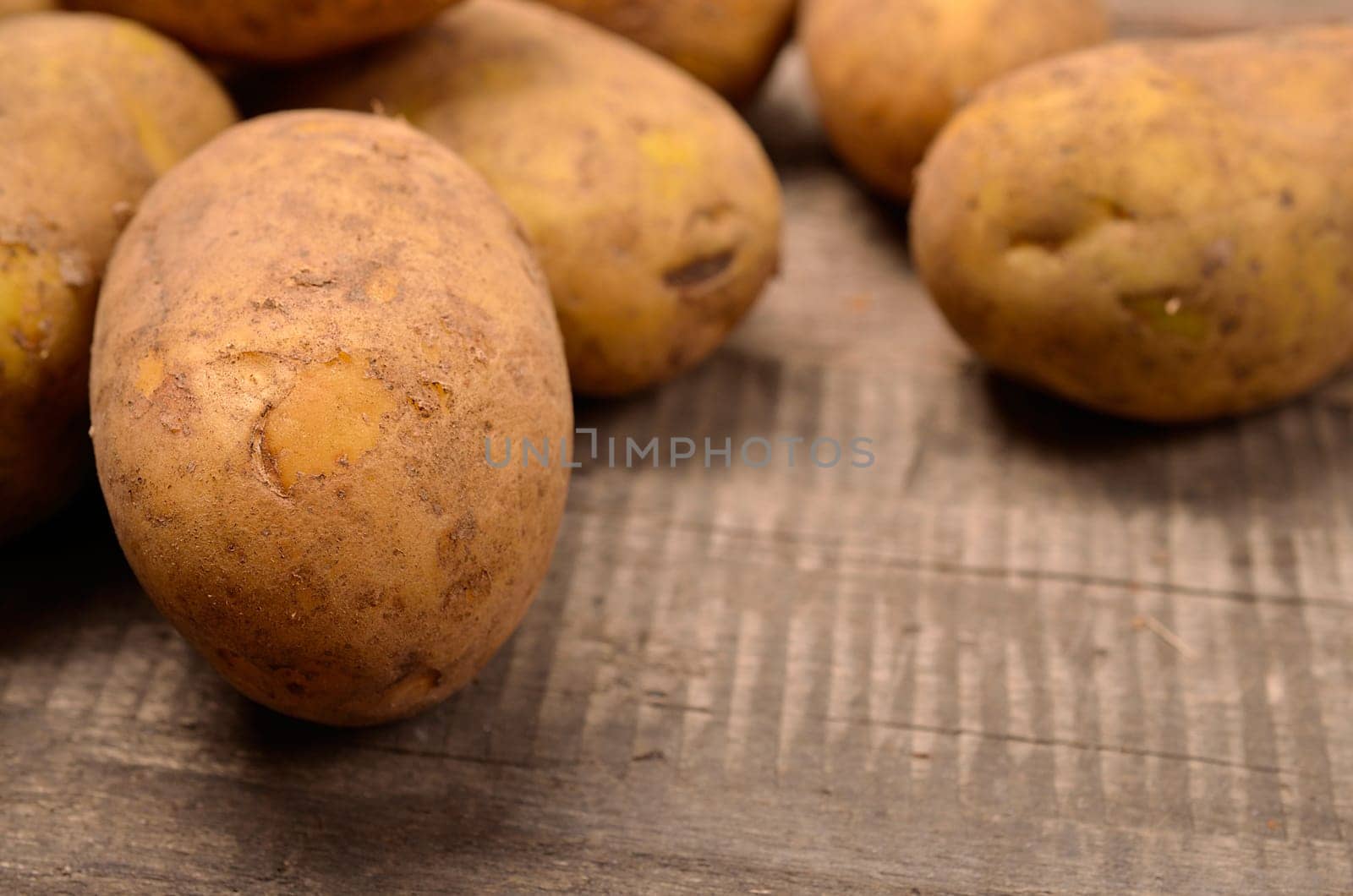 Close up of raw potatoes on a rustic wooden table