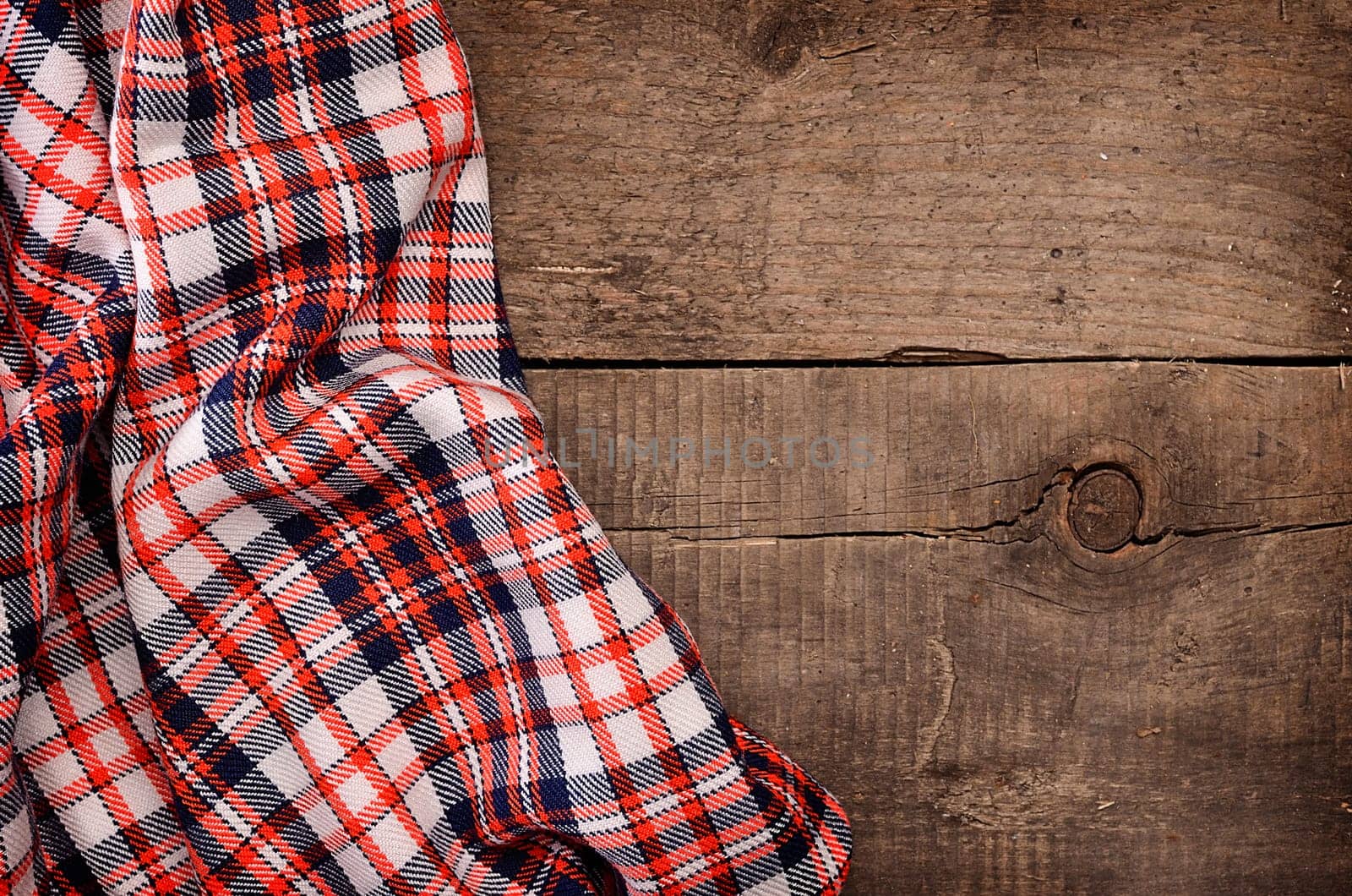 Checkered table cloth on a rustic wooden table with space for text or image